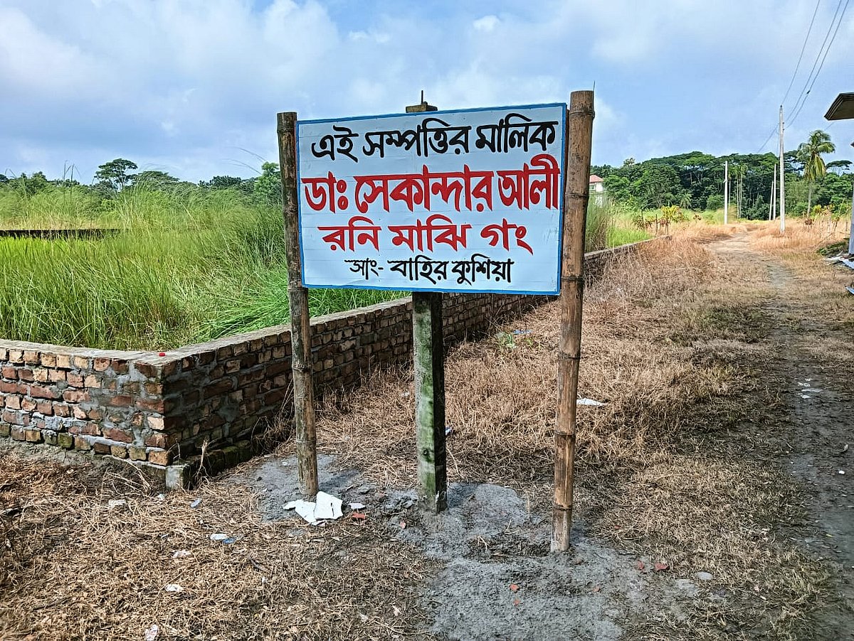 লোকজন নিয়ে জমি দখলের পর সাইনবোর্ডটি ঝুলিয়ে দেন রনি মাঝি। সোমবার তোলা